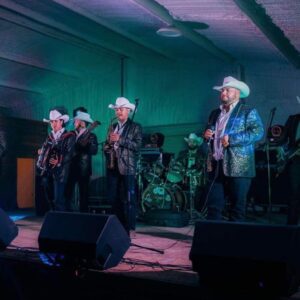 Musicians in glittery jacket performing on stage