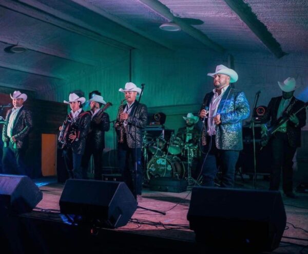 Musicians in glittery jacket performing on stage