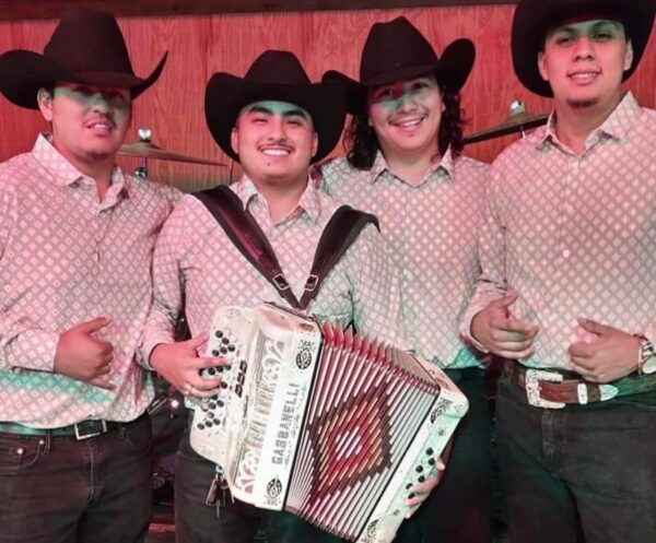 Musician playing accordion and others posing for picture