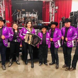 All musicians in lavender glittery jackets posing for a picture