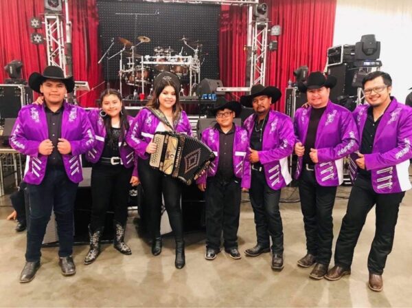 All musicians in lavender glittery jackets posing for a picture