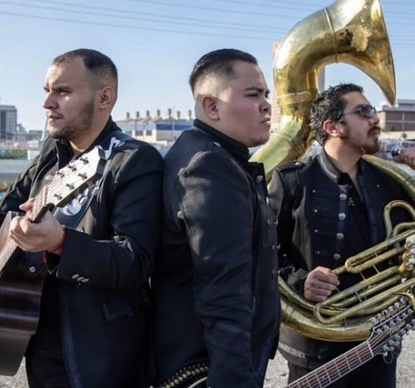 Man in black dress carrying French horn