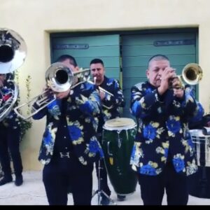 Musicians in fLoral dresses playing brass instrument and snare drums