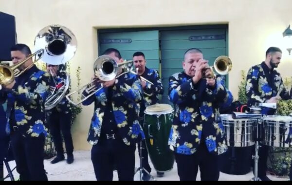 Musicians in fLoral dresses playing brass instrument and snare drums