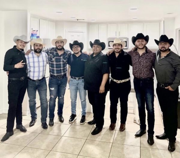 Musicians band posing for a picture with their cow boy hats and holding each other back