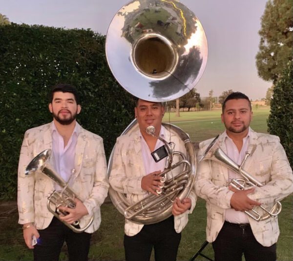 Musician holding saxophone and Trumpet and posing for a picture