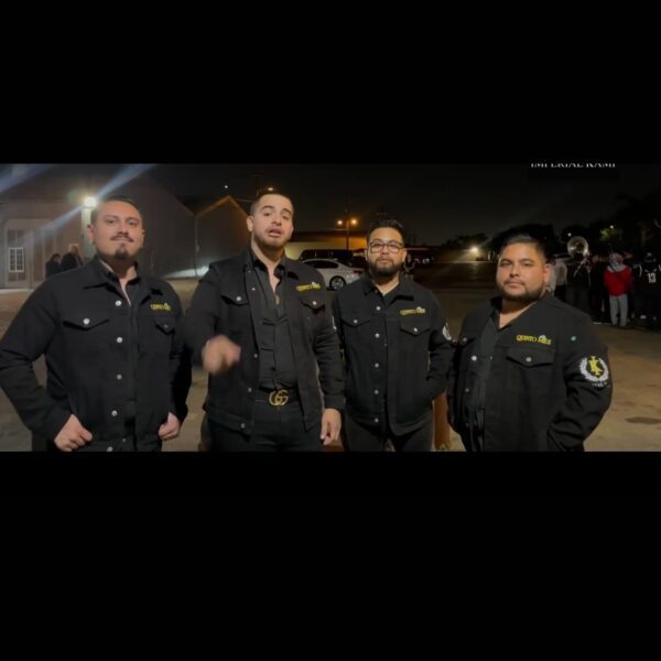 Music band dressed up in black posing on road