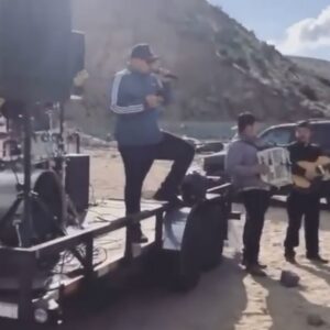 Musician standing on a vehicle and singing along with his troop