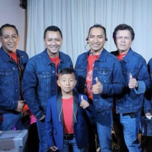 A music band all dressed in blue colour dress and posing with their music instruments