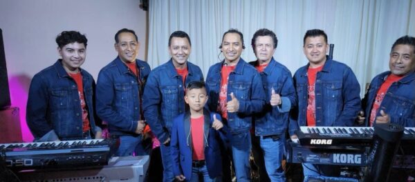 A music band all dressed in blue colour dress and posing with their music instruments