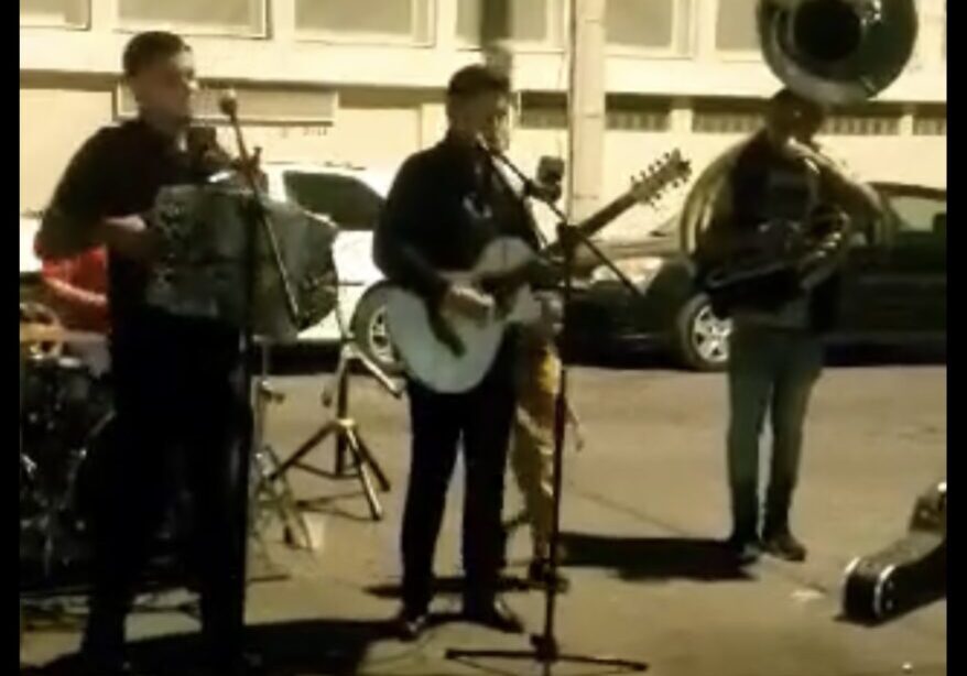 Musicians playing instruments and singing on road