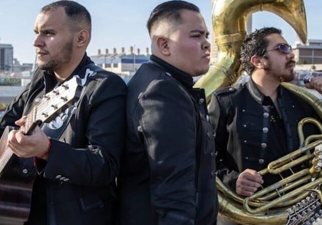 Man in black dress carrying French horn