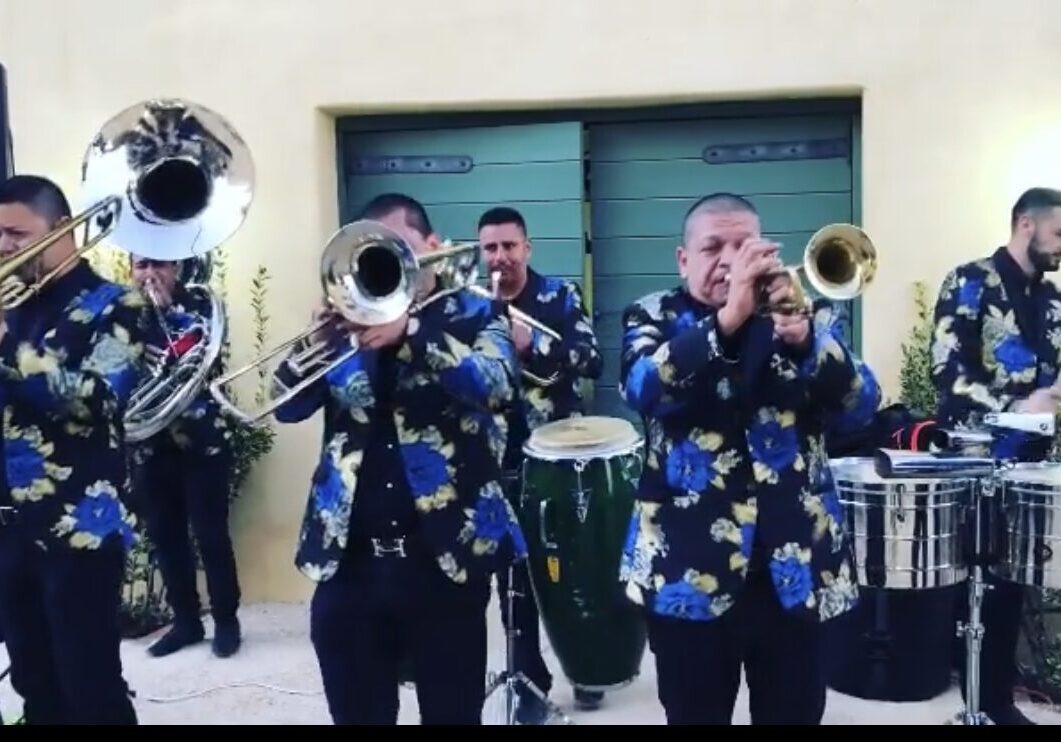 Musicians in fLoral dresses playing brass instrument and snare drums