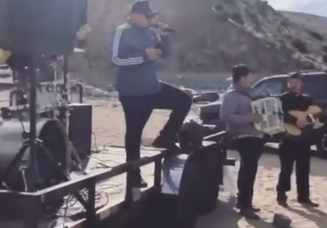 Musician standing on a vehicle and singing along with his troop